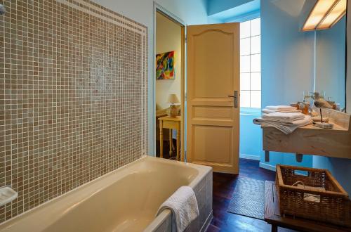 une salle de bain avec une baignoire et un lavabo dans l'établissement La Chaumière, Demeure d'hôtes, à Lauris
