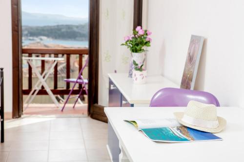 a hat sitting on a table in a room with a balcony at Residence La Marmorata in Santa Teresa Gallura