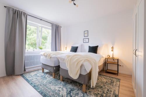 Un dormitorio con una cama grande y una ventana. en cruwzo I Apartment Rüttenscheid- Grün & Zentral, en Essen