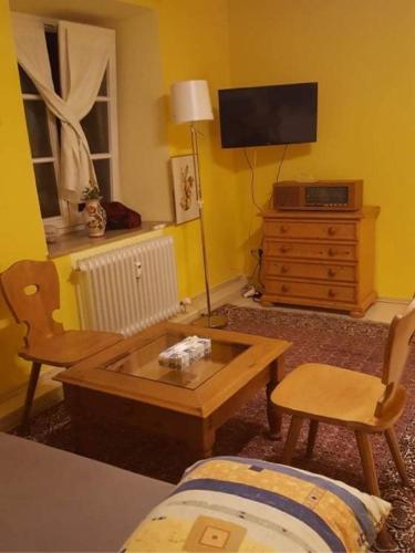 a living room with a tv and a table and chairs at Am-Berg Ferienwohnung in Bad kohlgrub in Bad Kohlgrub