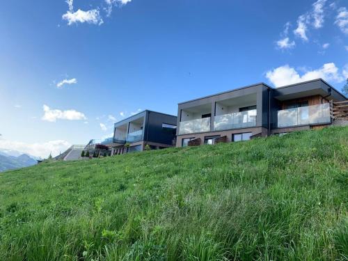 a building on top of a grassy hill at AGRITUR SEDICI - Bed and Breakfast in Tenna 