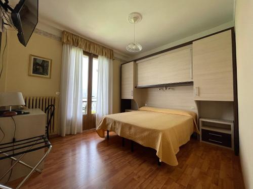 a bedroom with a bed and a wooden floor at Hotel Rabay in Brenzone sul Garda