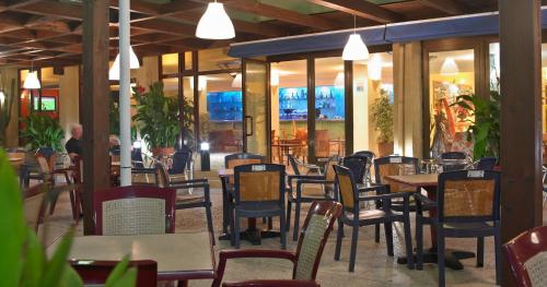 a restaurant with tables and chairs and people in the background at Hotel Apartamentos Londres La Manga in La Manga del Mar Menor