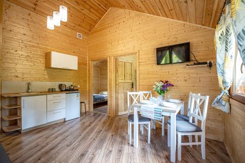 een keuken en eetkamer met een tafel en stoelen bij Dusznickie Domki Całoroczne in Duszniki Zdrój