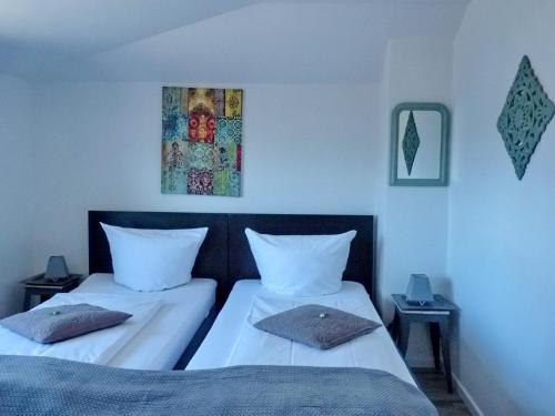 um quarto com duas camas e um quadro na parede em Haus am Burggraben em Hinte