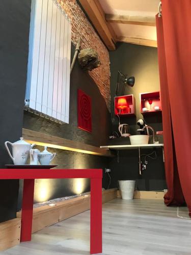 a red bench in a room with a sink and a table at Sanctus Syrus 2 in Albenga