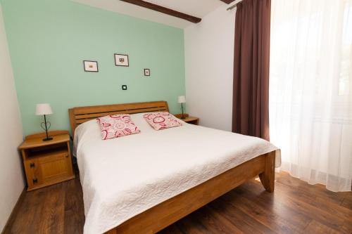 Un dormitorio con una cama con almohadas rosas. en Villa Melita, en Opatija