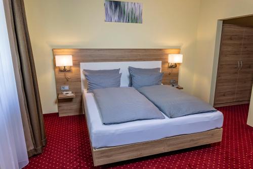 A bed or beds in a room at Hotel KonradP Holzkirchen