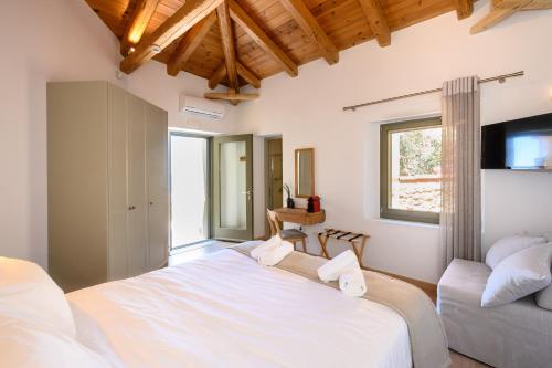 a bedroom with a large white bed and a couch at Selinitsa Residence Mani in Agios Nikolaos