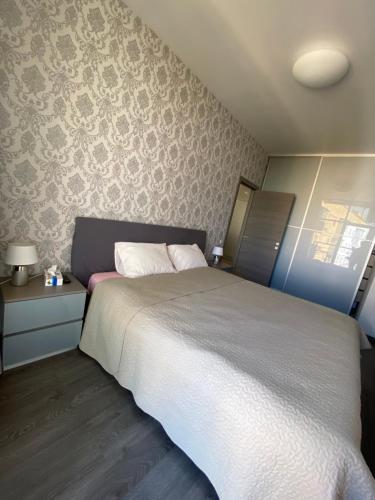 a bedroom with a white bed and a wall at Квартира, Апартаменты у моря, пляж Лузановка in Odesa