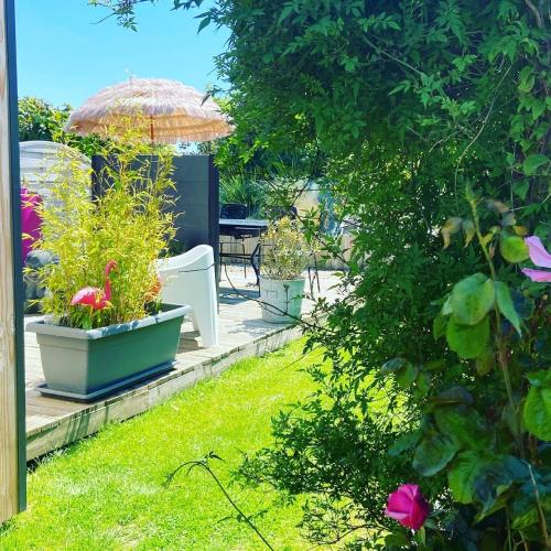 a patio with some plants and an umbrella at Entre Honfleur et Etretat in Octeville-sur-Mer