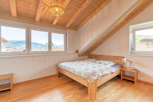 um quarto com uma cama e duas janelas em Ferienhaus Sigelalp em Blaichach