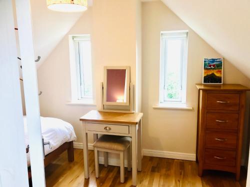 1 dormitorio con mesa, espejo y cama en Red Deer Cosy Apartment in Letterfrack Connemara, en Letterfrack