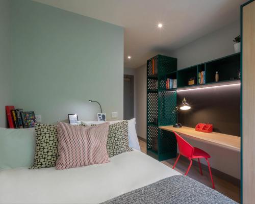 a bedroom with a bed and a desk with a red chair at JOIVY Affordable Dublin Thomas Street - Adults only in Dublin