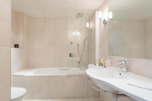 une salle de bain avec une baignoire, un lavabo et des toilettes dans l'établissement HOTEL ALISON, à Paris