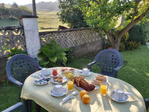 una mesa con desayuno de tortitas y zumo de naranja en Hospedaje Oreña, en Oreña