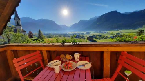 a table with a plate of food on a porch at Kalvarienberg Appartement Gosau in Gosau