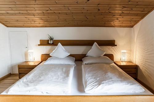 two beds in a room with two lamps on the wall at Residence Greymold in Rifiano