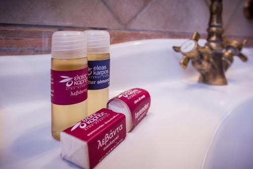 a bathroom sink with two bottles of lip balm and a candle at Acronafplia Pension A in Nafplio