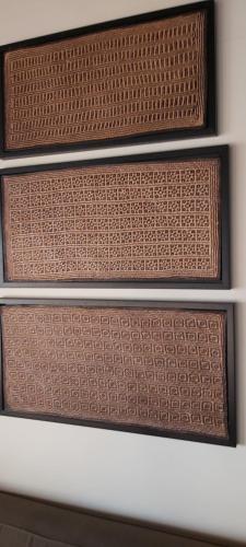 three wooden shelves with brown wicker and a white wall at 43 On Sandstone in Somerset West