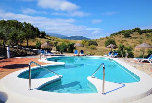una piscina en un complejo con sillas en Alojamientos Huetor, en Viñuela