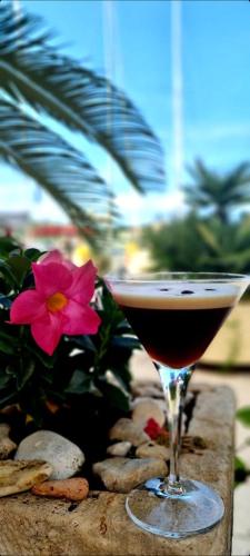 a glass of wine sitting next to a flower at Bed & Breakfast Dionis Vis in Vis