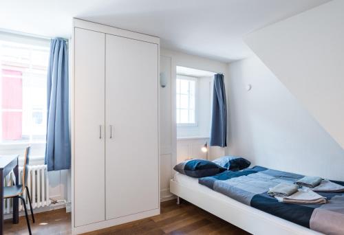 a bedroom with a bed and a large white cabinet at HITrental Schmidgasse - Apartments in Zurich