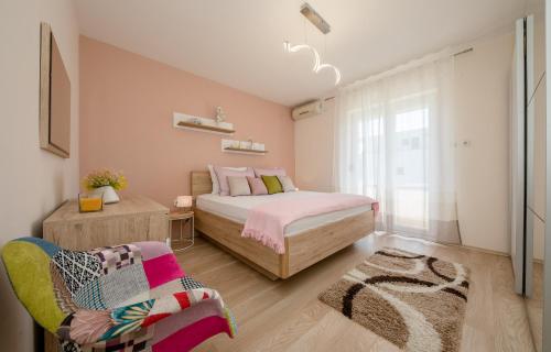 a bedroom with a bed and a chair at Apartments Luka in Rab