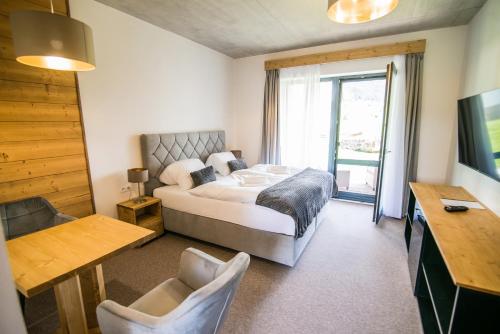 a bedroom with a bed and a desk and a window at Apartmány Tatry Žiarce in Liptovský Mikuláš