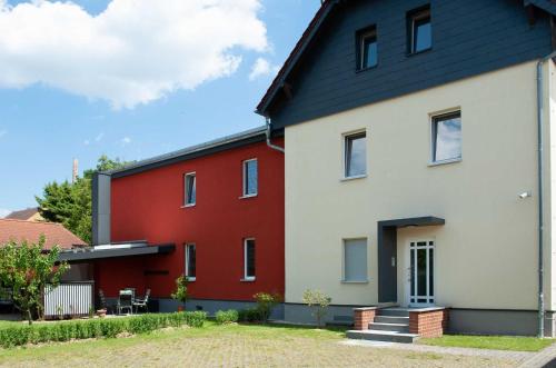 a white and red house with a black roof at Lausitzer Ferienapartments in Bernsdorf