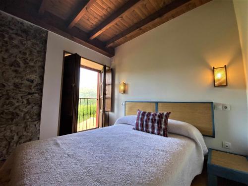 a bedroom with a large bed with a window at La Casina de Orfeo Cuenco Cangas de Onís VV-1901-A in Cangas de Onís