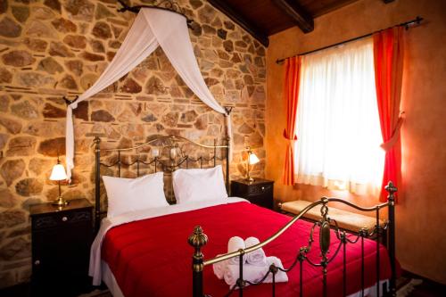 a bedroom with a bed with a red comforter at Acronafplia Pension A in Nafplio