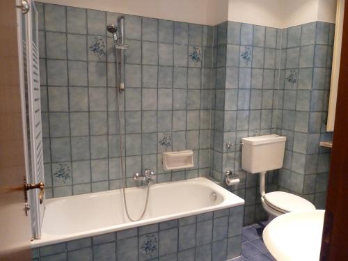 a blue tiled bathroom with a tub and a toilet at Hotel Antica Dogana in Turin