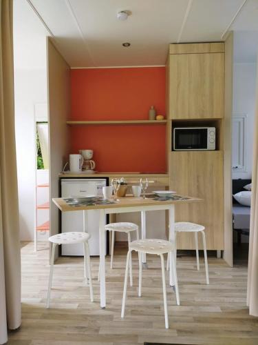 a kitchen with a table and chairs in a room at Verblijfpark Ardinam in Olloy-sur-Viroin