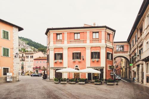 una calle con un edificio con sombrillas delante en La Rondine, en Tagliacozzo