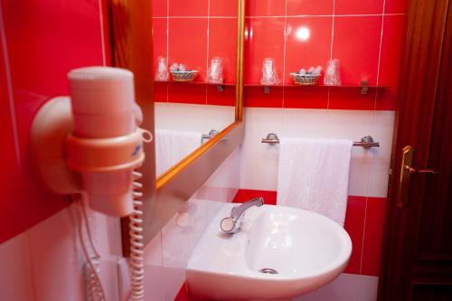 a red and white bathroom with a sink and a phone at Posada Peñas Arriba in Lon