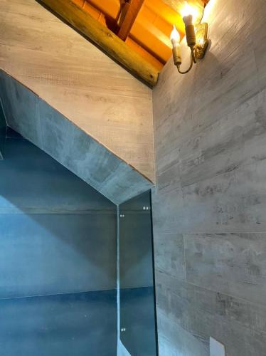 a glass shower in a room with a wooden ceiling at Hostel Casarão 65 in Salvador