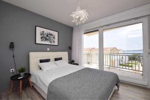 1 dormitorio con cama y ventana grande en Apartments Lueva, en Privlaka