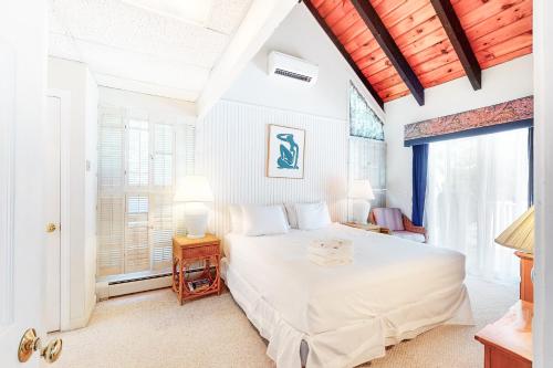 een slaapkamer met een wit bed en een raam bij Summersea in Mashpee