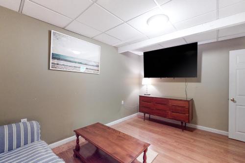 a living room with a flat screen tv on a wall at Summersea in Mashpee