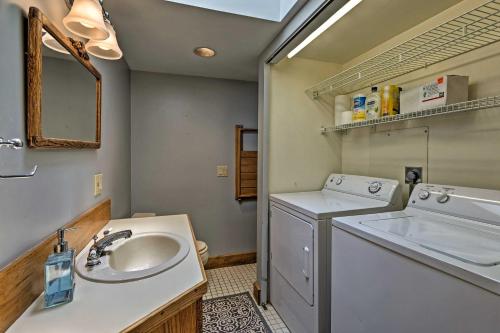 a bathroom with a sink and a washing machine at Common Fence Point Cottage with Ocean Views! in Portsmouth