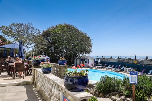 a pool at a hotel with a table and chairs at Marsham Court Hotel in Bournemouth