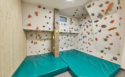 a room with a large rock climbing wall at Hotel Schachner in Saalbach Hinterglemm