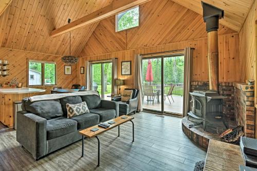 a living room with a couch and a stove at Near Snowmobiling! Riverfront Traverse City Cabin in Traverse City