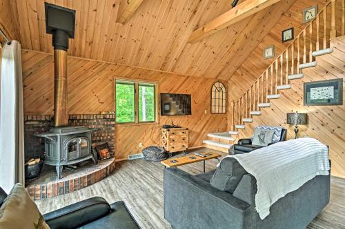 a living room with a couch and a stove in a cabin at Near Snowmobiling! Riverfront Traverse City Cabin in Traverse City