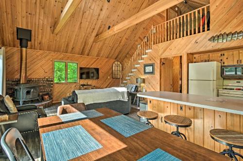 a kitchen and living room of a cabin with wooden walls at Near Snowmobiling! Riverfront Traverse City Cabin in Traverse City