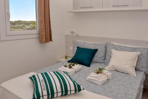 una camera da letto con un letto con due cuscini e una finestra di Tenuta l'Alba di Monte Matino - Mobil Home a Otranto
