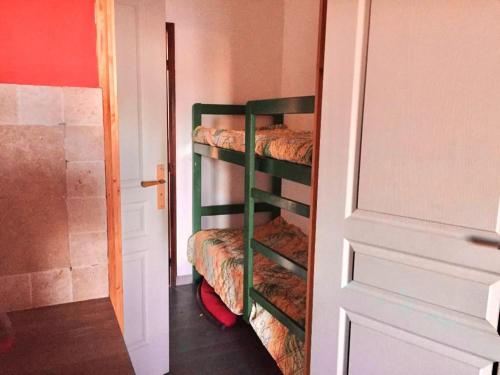 Cette chambre dispose de 3 lits superposés et d'une porte. dans l'établissement Studio charmant à Cervione avec piscine partagée - 30 m², à Cervione