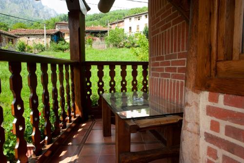 a table on the balcony of a house with a view at Posada Peñas Arriba in Lon