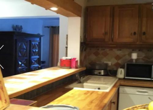 a kitchen with wooden cabinets and a counter top at Maison vue mer et montagne, Poggio-Mezzana in Poggio-Mezzana